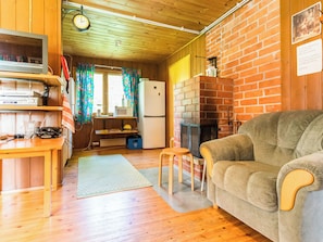 Una sala de estar acogedora con un sofá, un televisor y una chimenea de ladrillo.