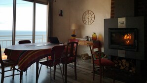 A dining area with a view of the sea, a fireplace, and a clock on the wall. - Village house, sea view, Cerbère (Cerbère)