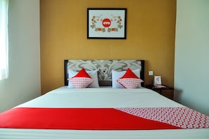Restful retreat with a neatly made bed and a unique piece of artwork above.