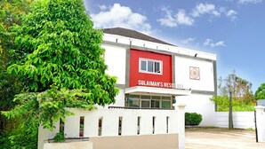 A modern building with a red and white facade, labeled "Sulaiman's Residence."