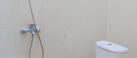 A bathroom with a toilet and a shower.