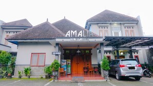 A guest house named "AMA" with a tiled roof, a wooden entrance, and potted plants. - Hotel O Guest House Amalia Malang (Malang)