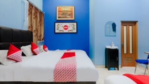 A bedroom with a bed, a nightstand, a mirror, a door, and a window with curtains. - Hotel O Guest House Amalia Malang (Malang)