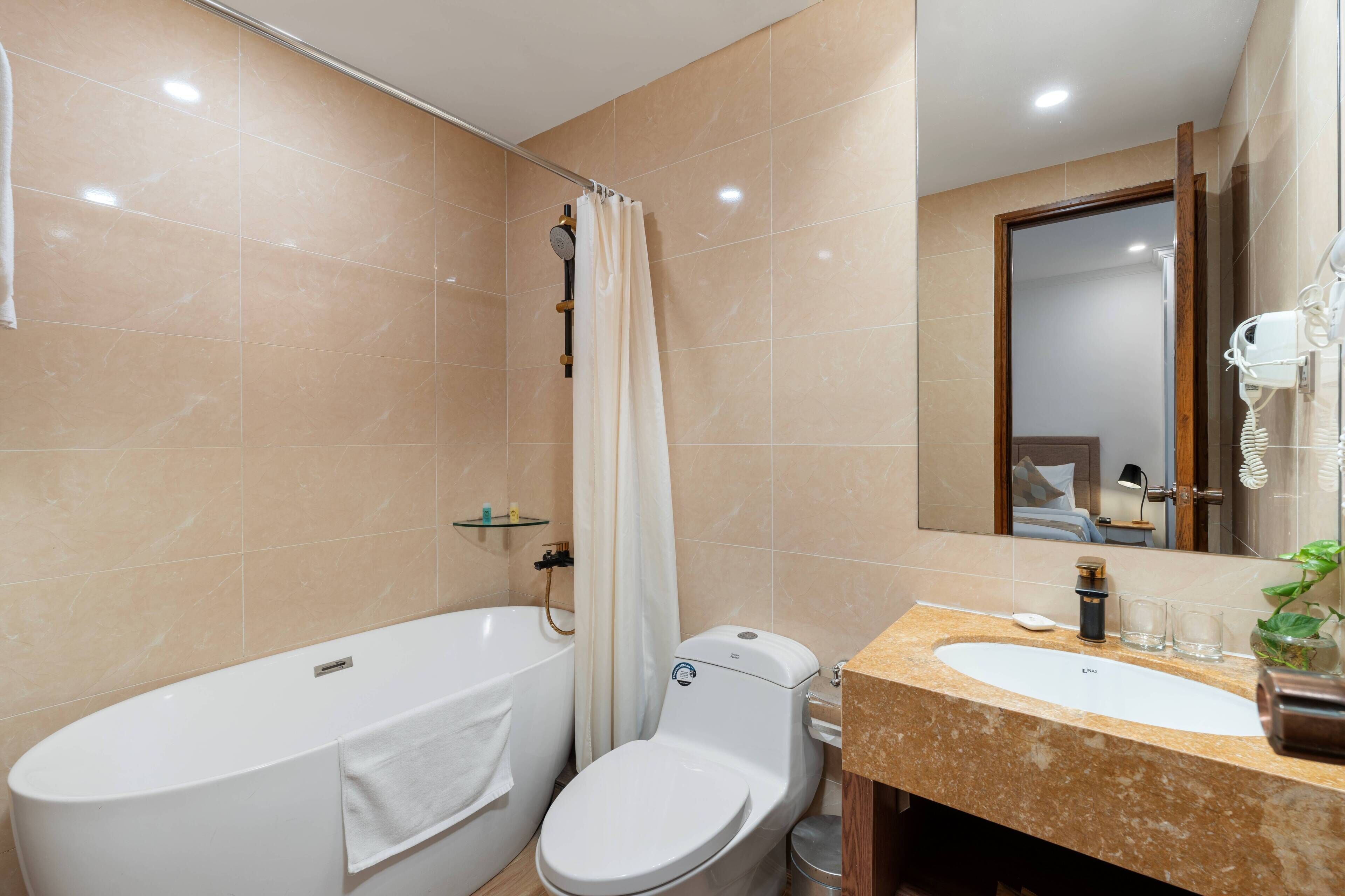 A bathroom with a bathtub, toilet, and sink.