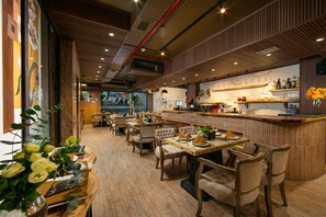 Un restaurant avec des meubles en bois, un coin bar et une vue sur la rue.