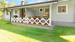 Een laag gebouw met een overdekte veranda en een witte picket fence.