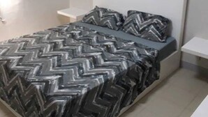 A bedroom with a bed, a nightstand, and a wall-mounted shelf. There are three framed pictures on the wall. - Simple & Cozy Accommodations (Lapu-Lapu)
