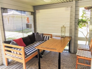 Een gezellige kamer met een houten bank, een gestreepte bank en een tafel.
