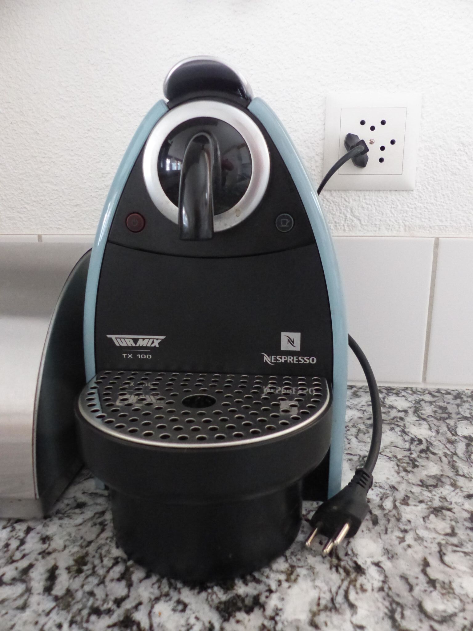 A coffee machine with a black and blue design, a digital display, and a Nespresso logo.
