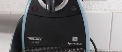 A coffee machine with a black and blue design, a digital display, and a Nespresso logo.