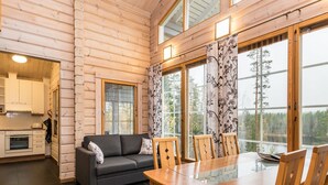 Een knus interieur van een chalet, met een eethoek, een bank en een keuken.