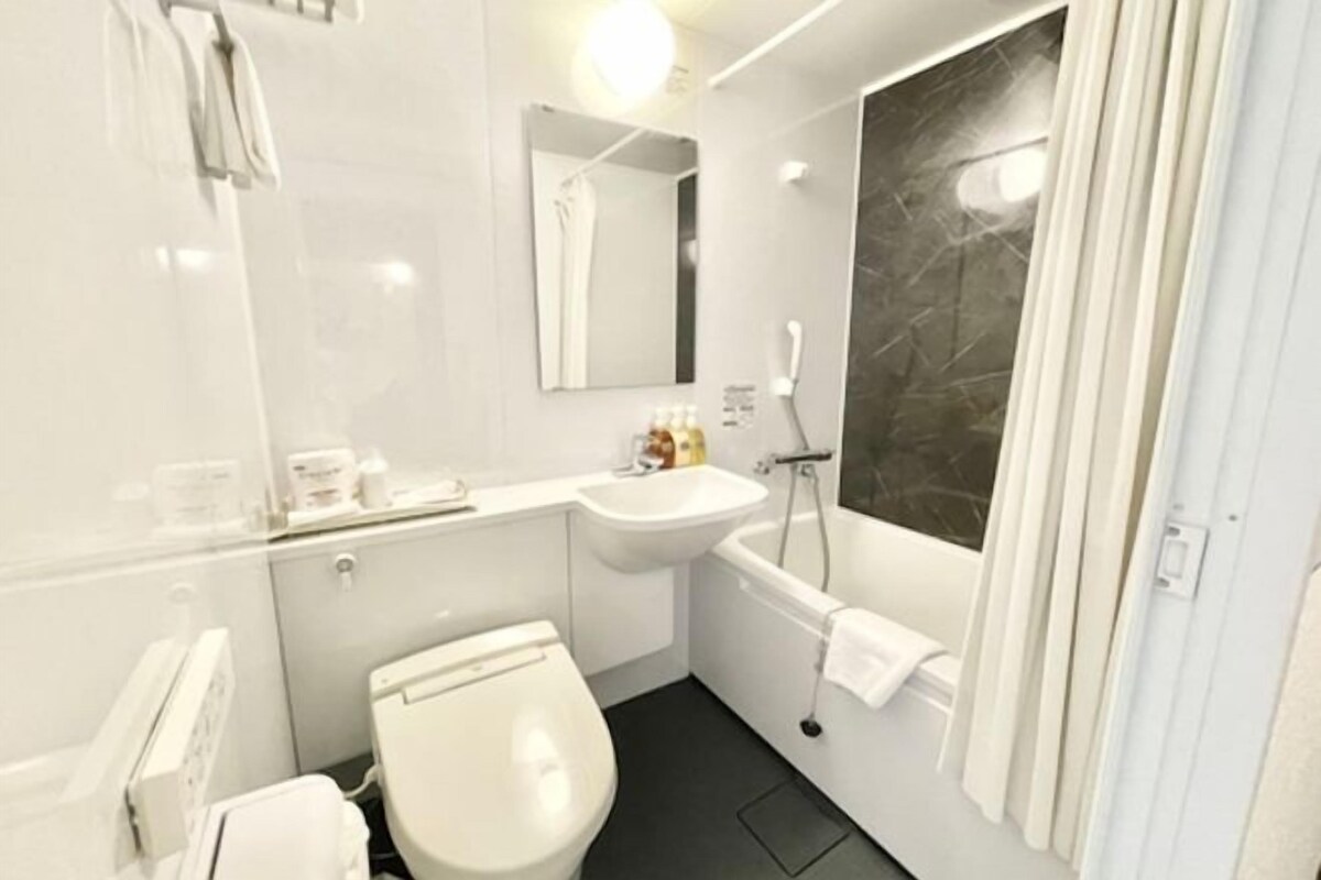 A modern bathroom with a toilet, sink, and bathtub.