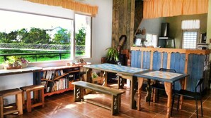 A cozy room with a large window, wooden furniture, a fireplace, and a bookshelf. - Mei Shiou BB (Dongshan)