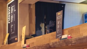 Un espace bar avec des chaises en métal et un comptoir en bois.