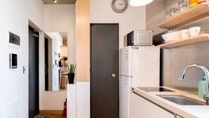 Una cocina moderna con un refrigerador empotrado, un microondas y un lavamanos.