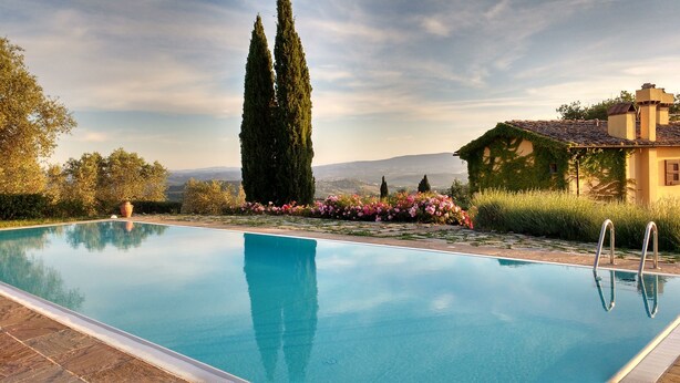A clear swimming pool with a tiled edge, surrounded by a garden with various plants and flowers. - Villa in the center of Tuscany, ideal for exploring the region or relaxing (CERTALDO)