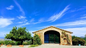 A stone building with a large arched doorway, surrounded by greenery and a clear blue sky. - Villa in the center of Tuscany, ideal for exploring the region or relaxing (CERTALDO)