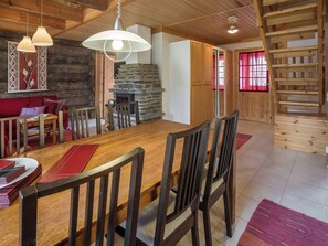 Una mesa de comedor de madera con sillas, una chimenea y una alfombra roja.