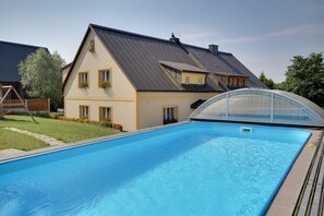 Una piscina con una casa al fondo.