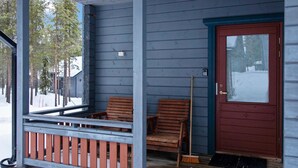 A wooden porch with two wooden chairs and a broom leaning against the wall. - Tunturitähti by Interhome (Äkäslompolo)