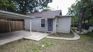 A single-story house with a garage, a covered porch, and a small front yard. - Cozy Remodeled 2br/2ba Near Downtown Sleeps 8 (San Antonio)
