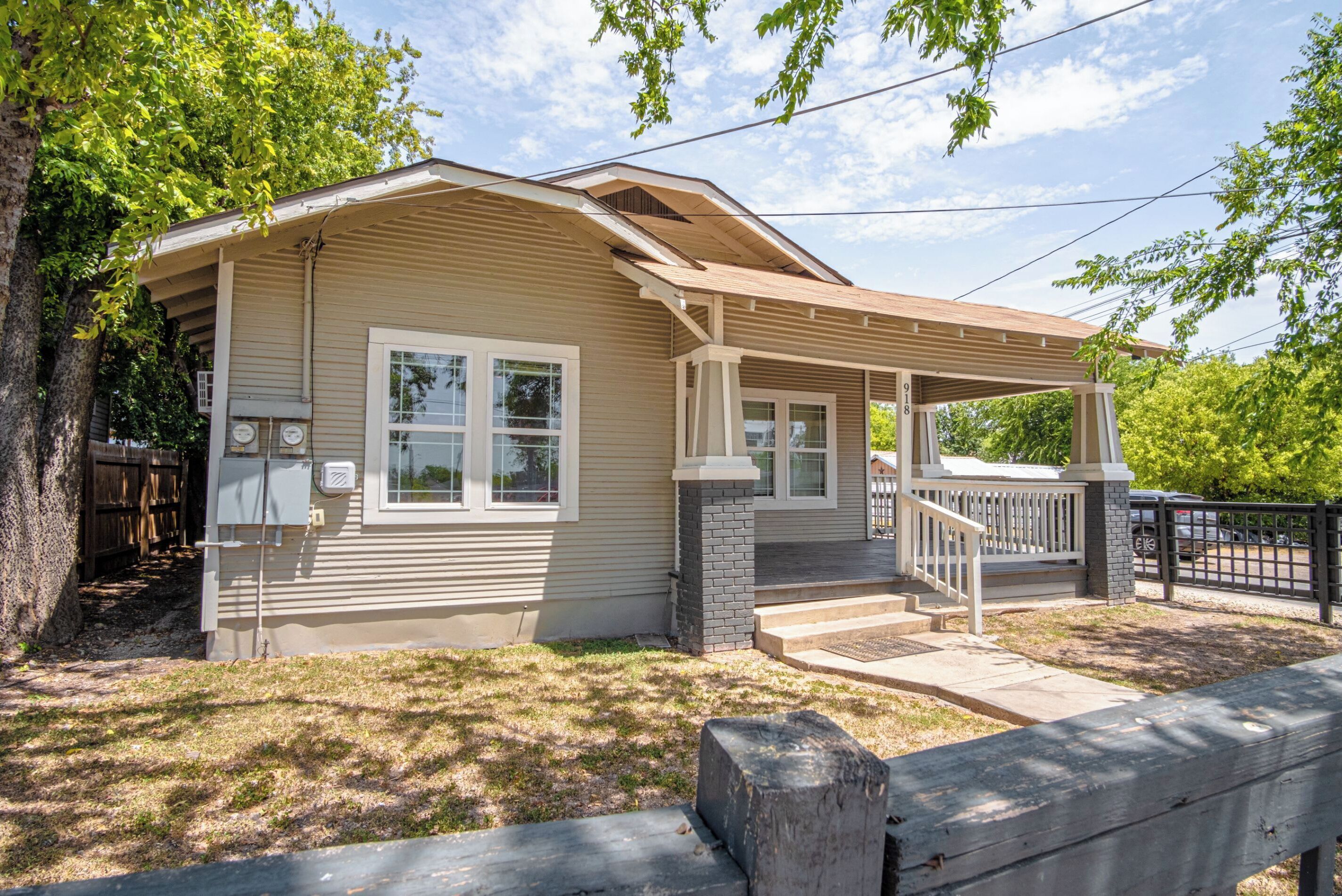 A single-story house with a covered porch, a front door, and a small front yard.