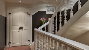 A staircase with white balusters and a door with a number '6' on it. - Mostecká 12 Residence (Prague)