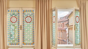 A room with two large windows featuring stained glass designs. - Mostecká 12 Residence (Prague)