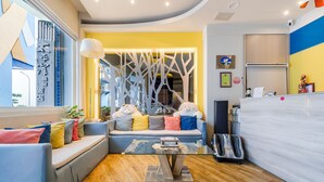 A modern hotel lobby with a sofa, a glass coffee table, and a reception desk. - Pacific Inn (Hengchun)