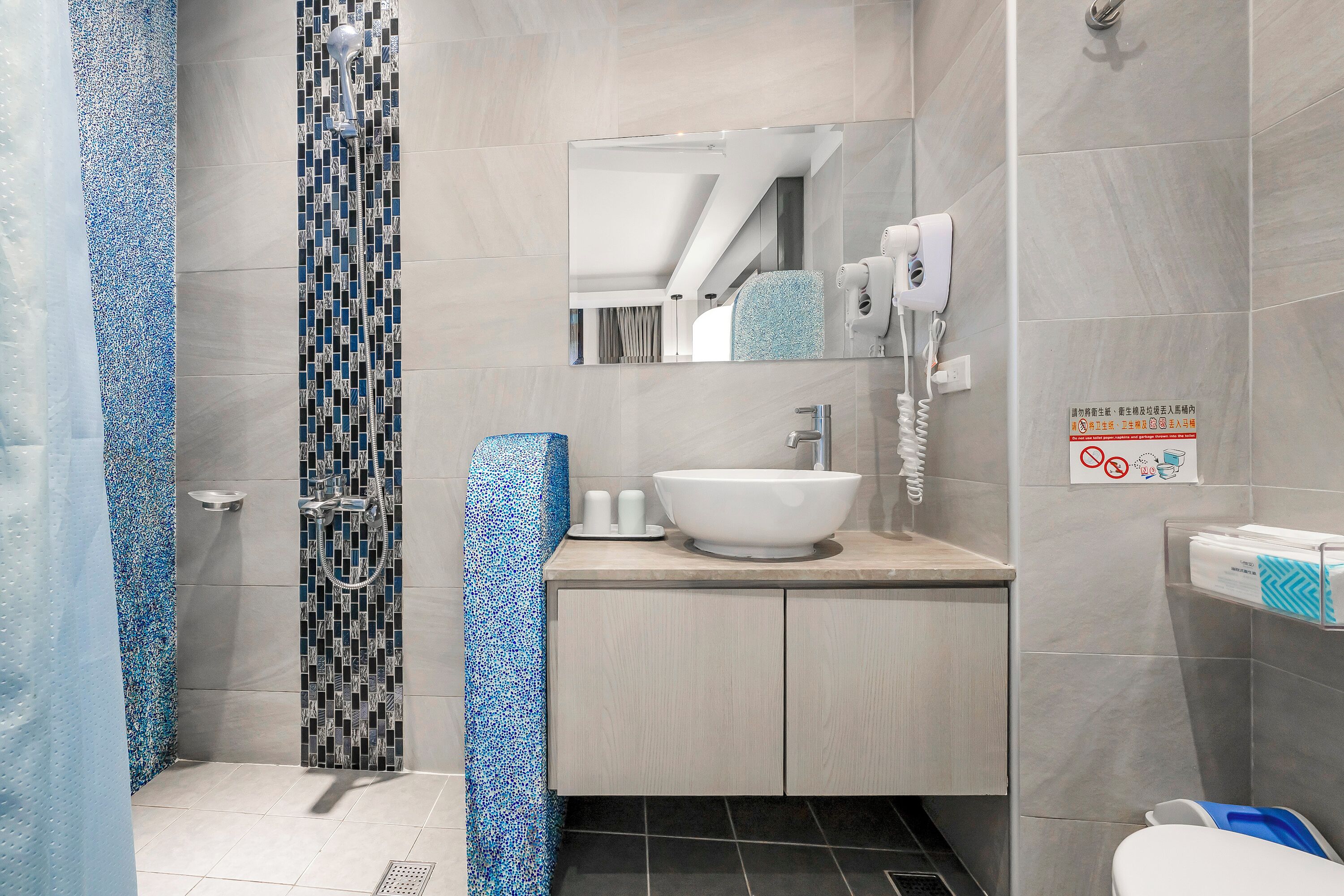 A modern bathroom with a shower, sink, and toilet.