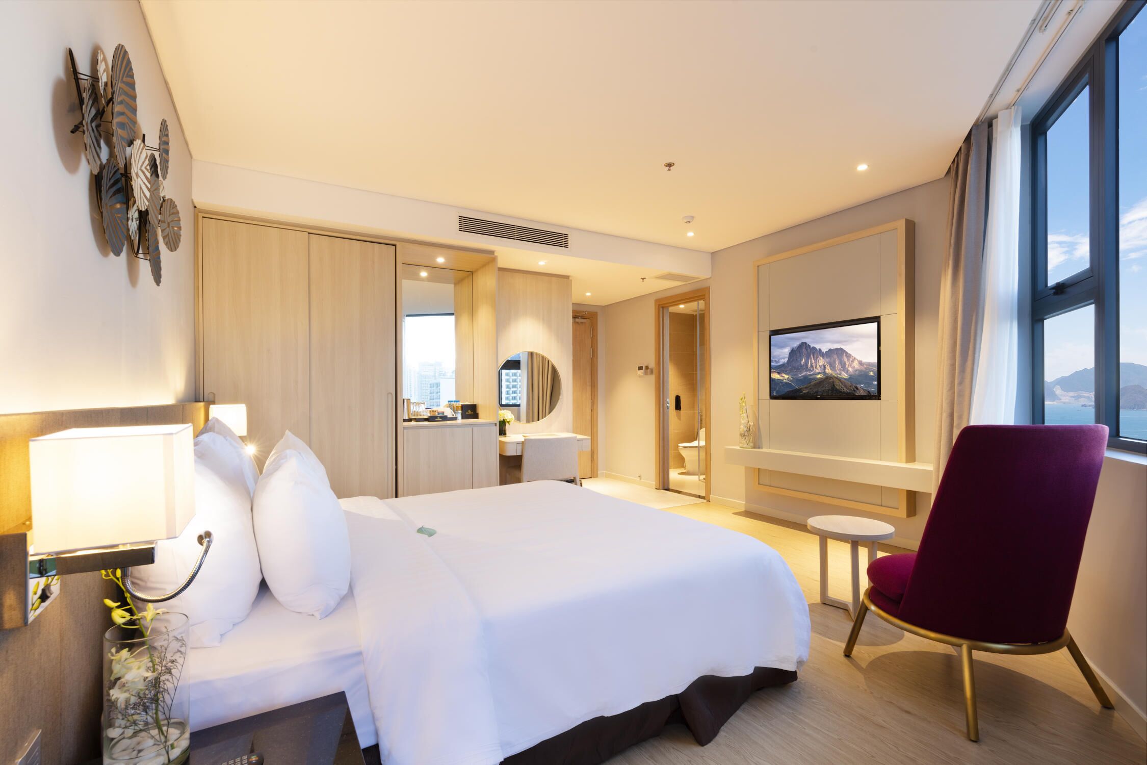 Une chambre d’hôtel avec un grand lit, un bureau, une chaise et un téléviseur.