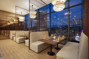 Un comedor moderno con techos altos, ventanas amplias e iluminación contemporánea.