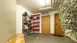 A hallway with a wooden bench, a shoe rack, a potted plant, and a door. - Apartment Azurit by Interhome (Saas-Fee)
