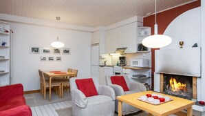 Una sala de estar moderna con chimenea, un comedor y una cocina.