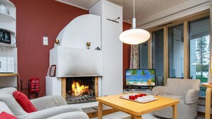 Una sala de estar acogedora con chimenea, televisor y asientos cómodos.