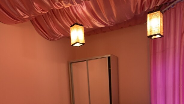 Quarto com cama, cadeira, televisão e guarda-roupa.