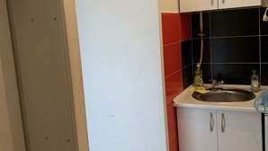 Uma cozinha com armários brancos, uma pia e um backsplash com azulejos vermelhos e pretos.