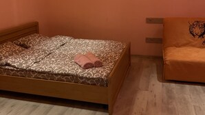 Quarto com uma cama, uma cadeira e duas luminárias pendentes.