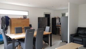 Un espace de vie compact comprenant une table à manger, des chaises, un canapé et un coin cuisine.