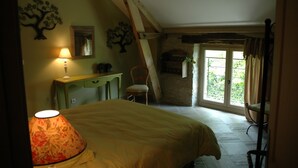 A bedroom with a bed, a desk, a chair, and a window with a view of greenery. - Au Picatal (Meyronne)