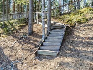 A wooden staircase in a forested area with a wooden fence and trees. - Honkakoli 9/1 by Interhome (Lieksa)