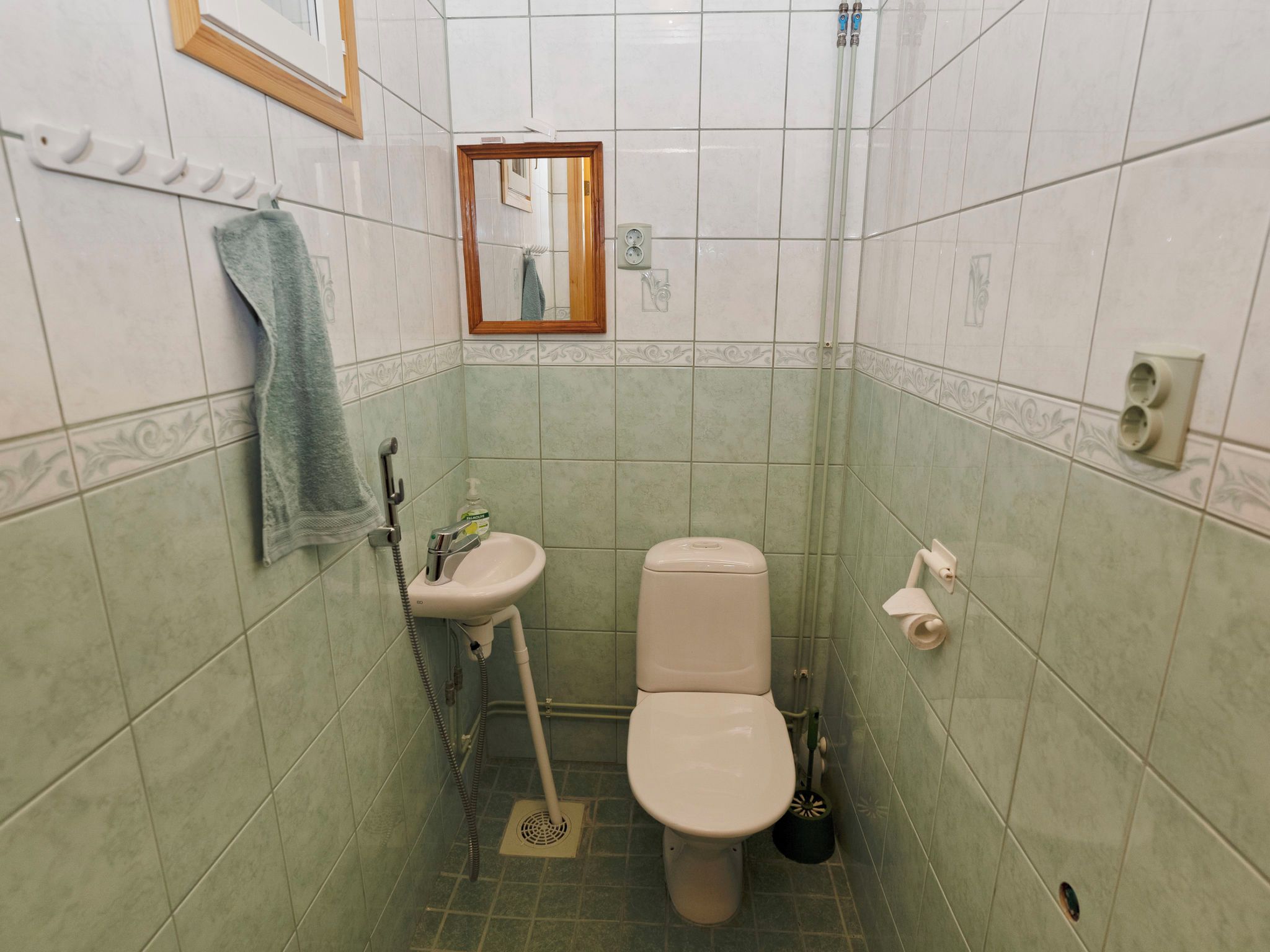 A small bathroom with a toilet, sink, and shower.