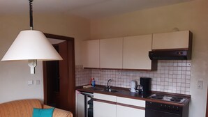 A compact kitchen with a dining area, a sofa, and a table. - Haus Seeblick (Neuwerk)