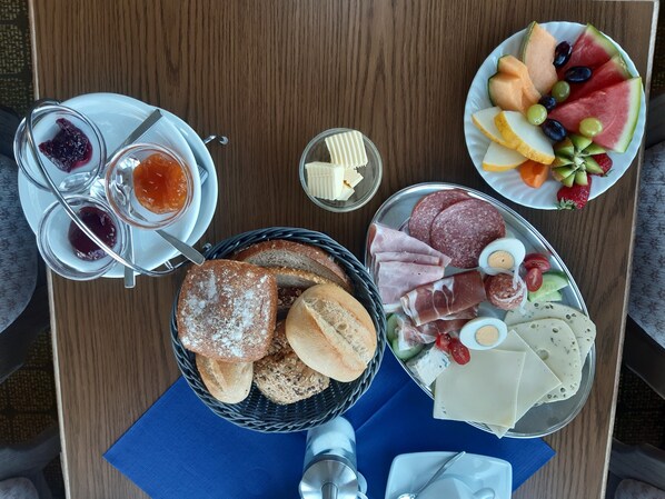 A breakfast buffet with bread, meats, cheeses, fruits, and jams. - Haus Seeblick (Neuwerk)