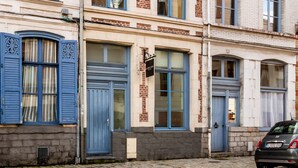 A row of historic buildings with distinct architectural styles, including brick facades and blue shutters. - Au Chat Qui Dort Lille - Magasin  (Lille)