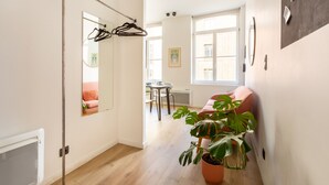 A modern interior with a hallway leading to a dining area, a mirror, a potted plant, and a wall with a motivational quote. - Au Chat Qui Dort Lille - Magasin  (Lille)