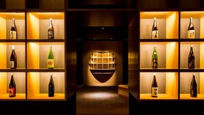 A corridor with shelves on either side displaying various bottles. - Hatagoya Jyozankei Shoten - Hostel (Sapporo)