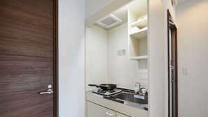 Una cocina compacta con estufa, lavamanos y armarios.