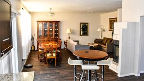 A modern living room with a dining area, a fireplace, and a kitchen. - Advantage Court (Las Vegas)