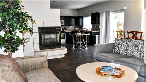 A modern living room with a fireplace, a round coffee table, and a grey sofa. - Advantage Court (Las Vegas)